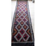 An Afghan hand-knotted Suzani Kilim blue-ground wool runner with multi-coloured isometric designs,