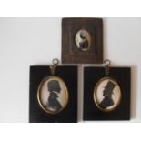 A Victorian silhouette reverse-painted profile of a woman in bubble convex glass (damaged) and