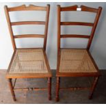 A pair of late Victorian walnut-framed bedroom or occasional chairs with rattan seats, ladder-back