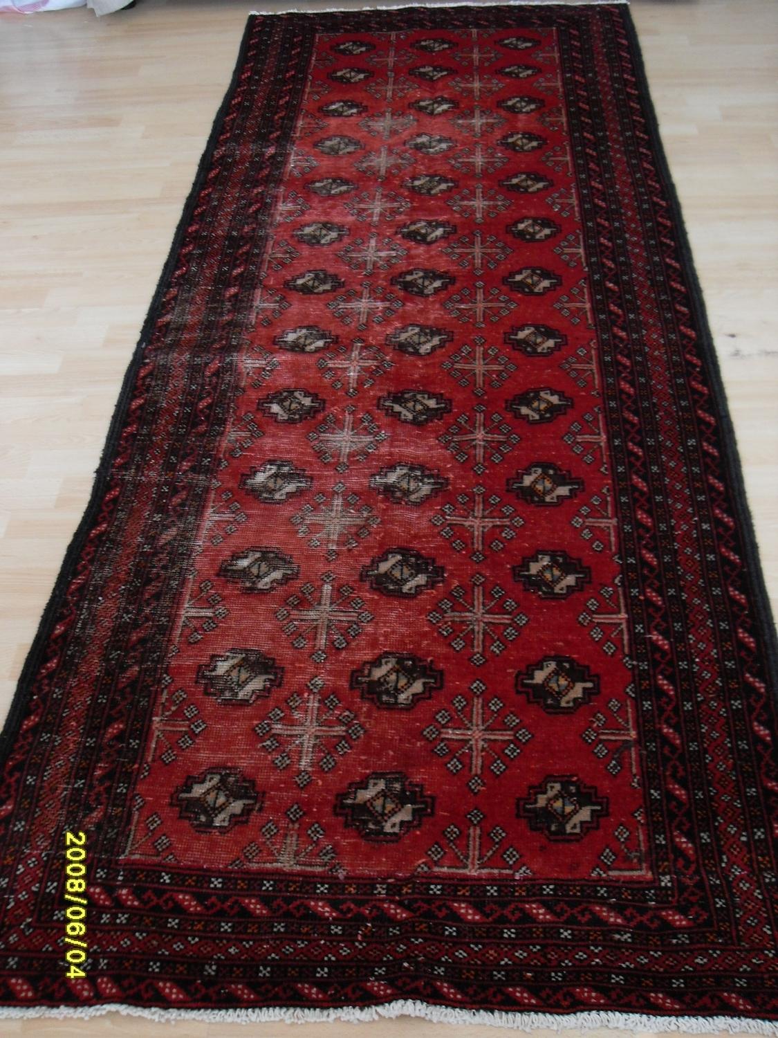 A Persian hand-knotted Turkman-style burgundy-ground wool runner with contrasting multicoloured