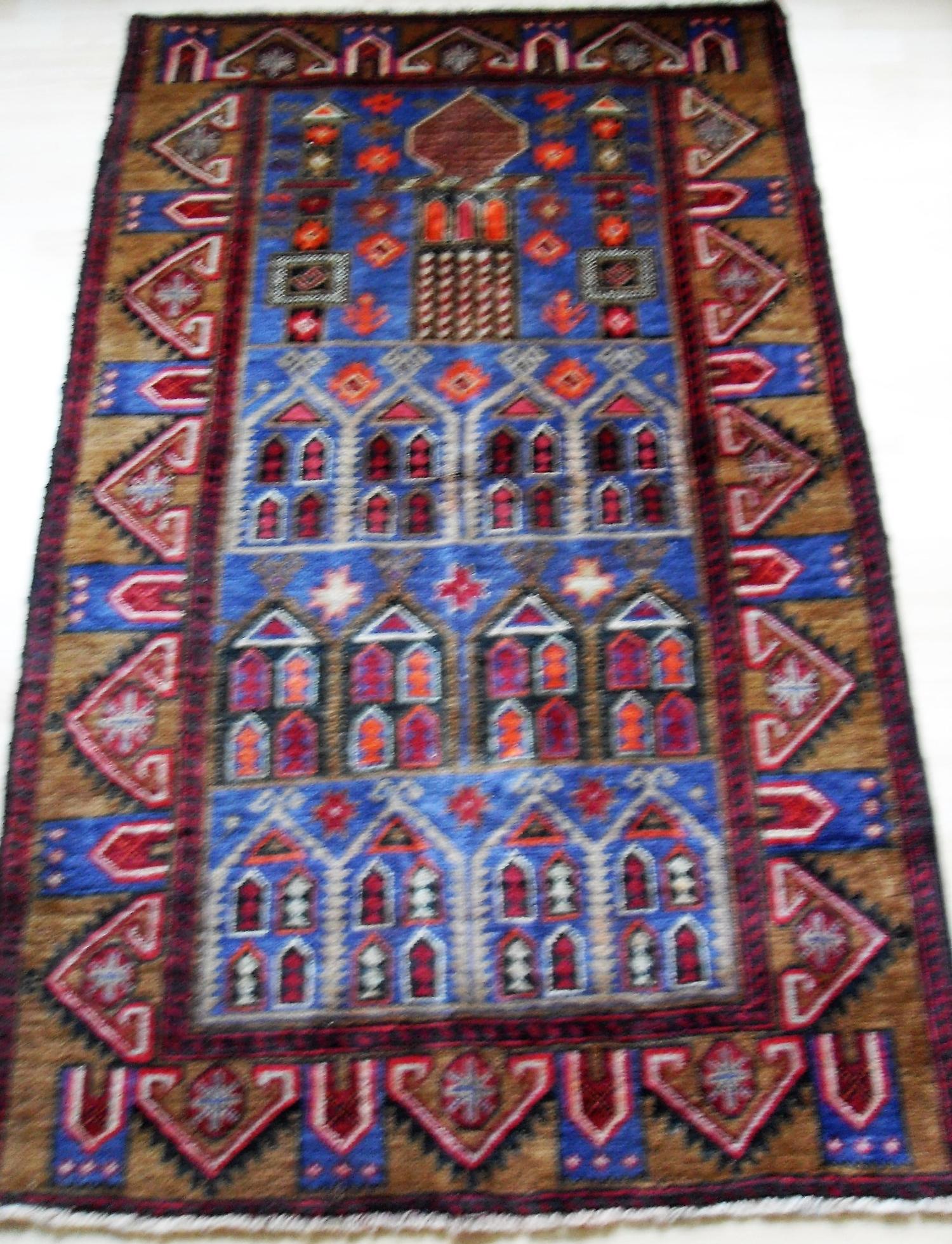 An Afghan hand-knotted Herathi Balochi blue-ground wool rug with multi coloured isometric designs,