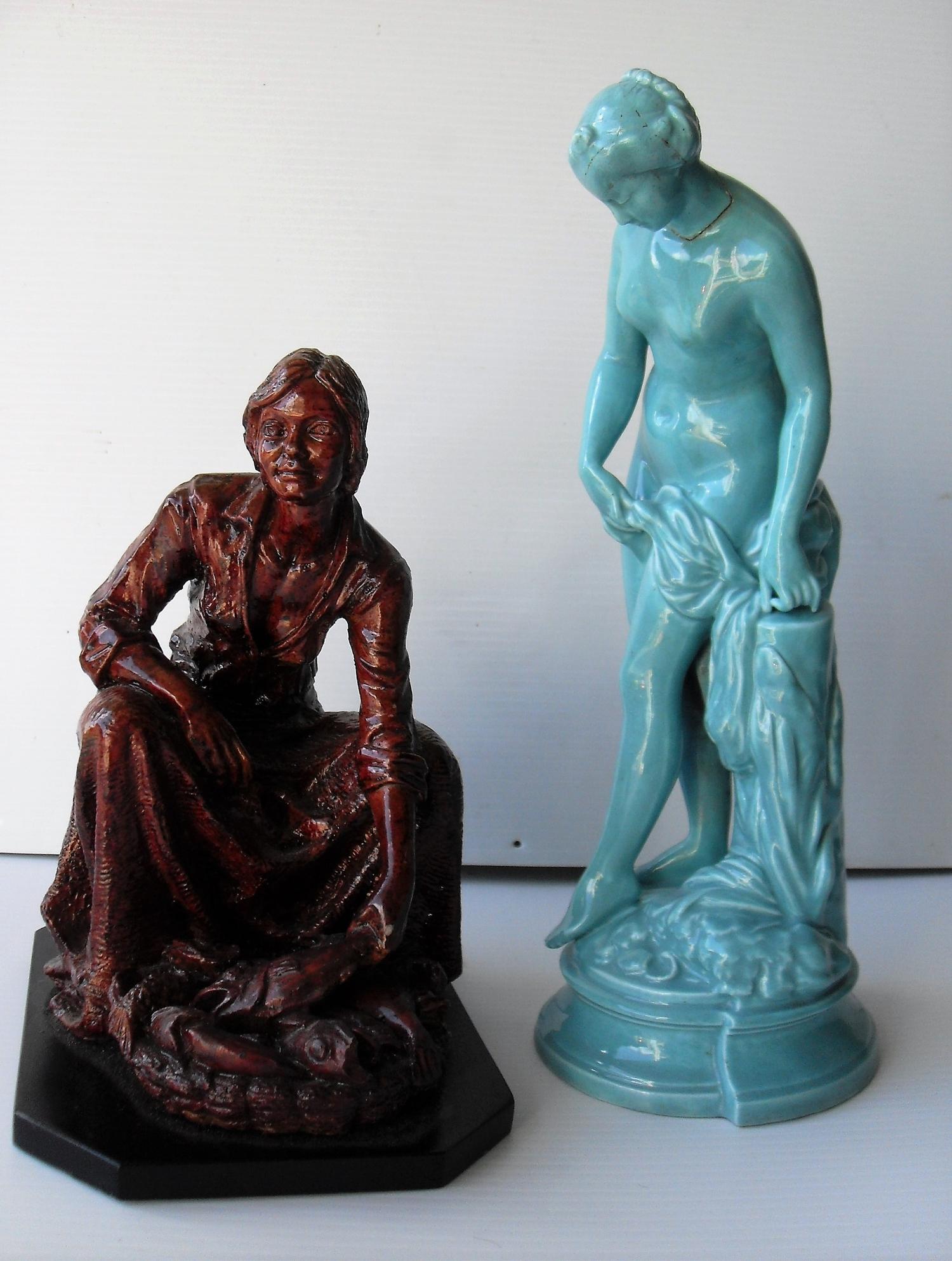 Two ceramic figurines: a seated fisherwoman selling fish and a classical maiden (repair to head/