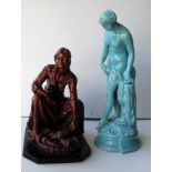 Two ceramic figurines: a seated fisherwoman selling fish and a classical maiden (repair to head/