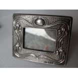 An Art Nouveau silver photo frame with easel-back support and stylised floral designs by A & J