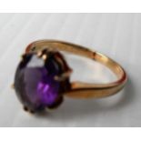 A 9ct yellow gold oval mixed-cut amethyst 10.5 x 7.97 x 4.5mm in a claw setting, size O, London