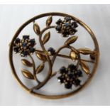 A 9ct yellow gold floral and foliate circular brooch with sapphire accents, 2.5cm diameter, 3.42g