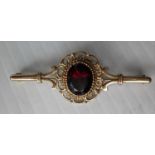 An early 20th century 9ct gold and ruby (9 x 11mm approximately) brooch 5 x 2 cm with filigree