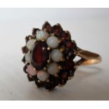 A 9ct yellow gold ruby and opal cluster dress ring in a cage setting, size Q 1/2, hallmarked for