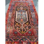 A Persian hand-knotted burgundy-ground Hamadan wool rug with multicoloured isometric designs, double