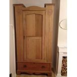 An Arts & Crafts light oak single wardrobe with stylized floral carvings, original hooks to