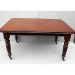 A Victorian mahogany wind-action extending dining table with two extra leaves, turned legs