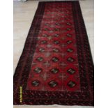 A Persian hand-knotted Turkman-style burgundy-ground wool runner with contrasting multicoloured