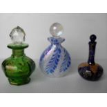 Three various glass scent bottles and a small hand mirror with painted floral decoration, 10 - 12 cm