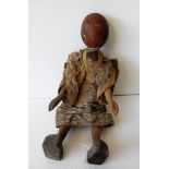 An articulated carved wooden Oriental female doll with painted features, traditional dress (