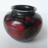 A Moorcroft miniature vase with pomegranate pattern, green glaze and decorator's mark to base, 7