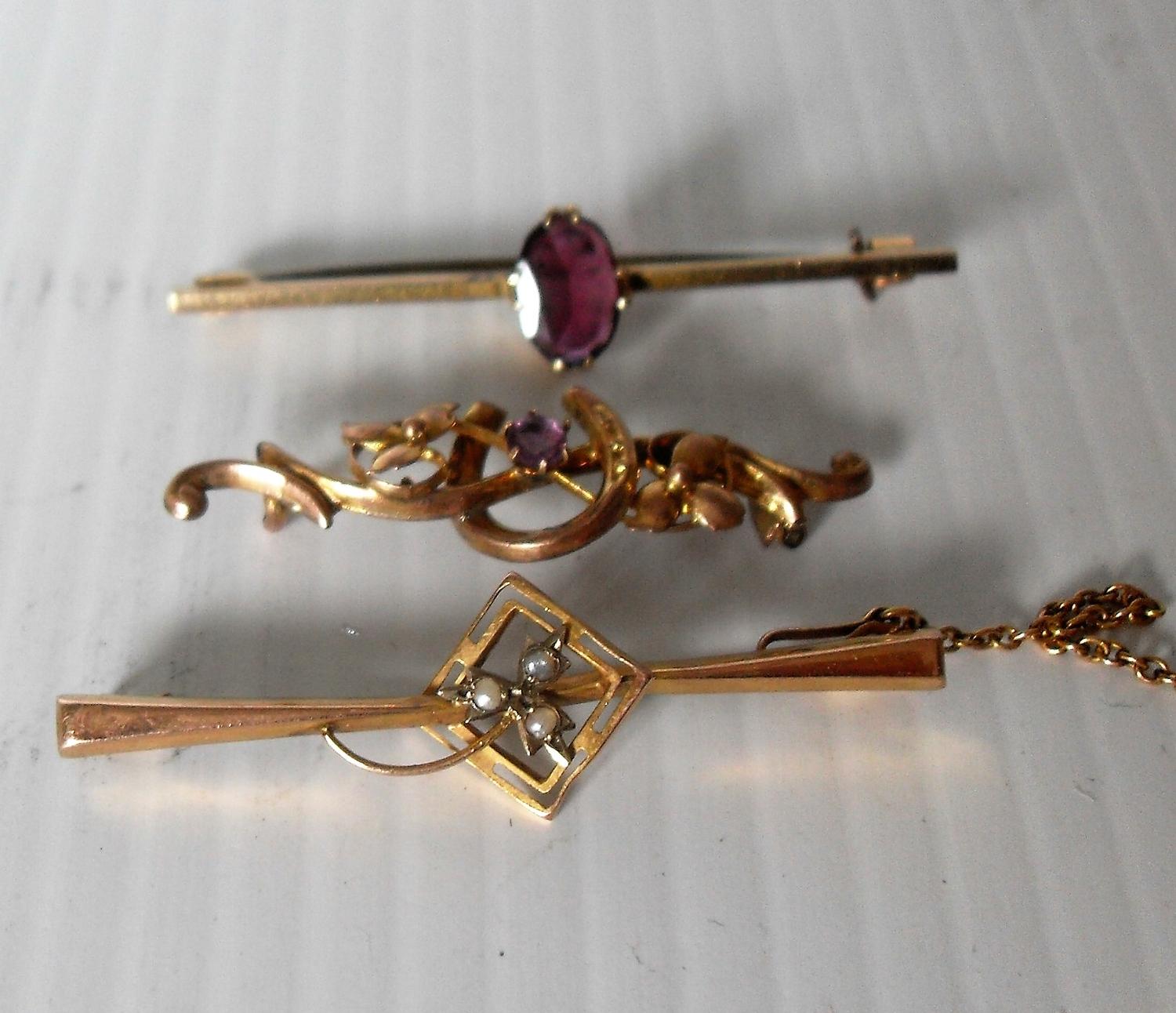 Three 9ct yellow gold bar brooches, two with amethyst stone decoration, the other with seed