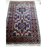 An Afghan hand-knotted maroon-ground Herathi Balochi wool rug with isometric designs, double