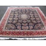 A Middle Eastern blue-ground hand-knotted wool rug with multi-coloured floral designs, double border