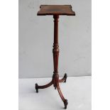 A George IV walnut torchere stand with square platform top, fluted and turned support with entasis