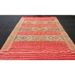 A Moroccan Berber burgundy-ground hand-knotted wool rug with multi coloured designs, 305 x 220 cm