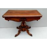 A Victorian rosewood fold-over tea table with octagonal baluster support, C-scroll and anthemion