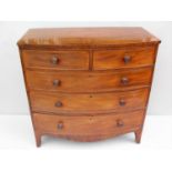 A Regency mahogany bow-fronted chest of two short and three long graduated drawers with turned