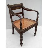 A George IV painted colonial carver with shaped arm supports, rattan seat on fluted legs, 83 cm H