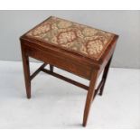 An Edwardian mahogany music stool with lift-up embroidered seat on square legs and H-shape