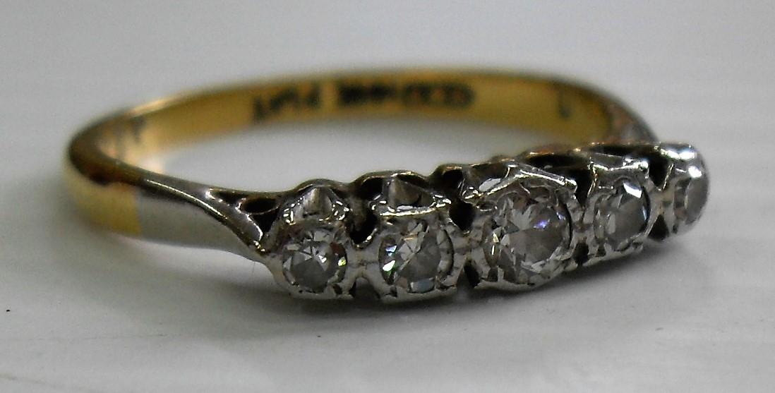 A five-stone diamond gold and platinum ring, stamped 18ct. Diamonds illusion set, centre diamond,