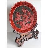 An early 20th century Chinese cinnabar dish with floral depiction in a mountainous background on