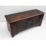 A 17th century oak coffer with Tudor Rose carving to front panel, hinged lid on bracket feet, 49 x