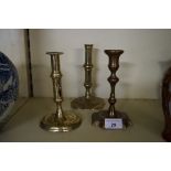 Three assorted Georgian brass candlesticks.