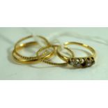 A 22ct gold band, together with, to yellow metal twist bands, a diamond five stone ring,