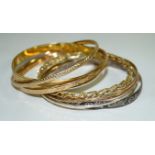 A collection of 9k and yellow metal bangles, of various designs and colours,