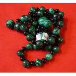 A string of malachite beads, interspaced by black beads,