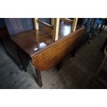 A late 18th/early 19th Century mahogany drop leaf table raised on chamfered block supports.