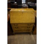 An Art Deco style burr walnut bureau, having fall front and three drawers,
