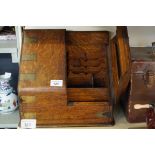 A 1920s brass bound stationery cupboard with an assortment of compartments.