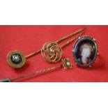 Three yellow metal stick pins, unmarked, with various designs and pearl detail, together with,