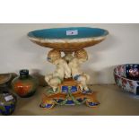 A reproduction Majolica centre piece modelled with three cherubs seated supporting a bowl.