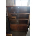 A Minty mahogany three sectional bookcase, two glazed sliding doors, two panelled cupboard doors.