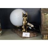 An Art Deco desk lamp modelled in a gilt spelter alastain beside milk glass shade.