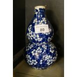 A modern blue and white double gourd vase with a prunus style decoration.