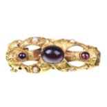 An early Victorian gem-set brooch The central oval cabochon-cut garnet,