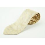 An Hermes silk tie The pale yellow ground with a light blue polka dot repeating pattern,