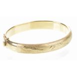 An Italian 18ct gold hinged bangle With engraved and chased leaf decoration, with safety catch,