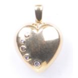 A diamond set heart pendant The yellow metal heart pendant set with five graduated round