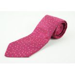 An Hermes silk tie Of typical form, with ribbed, deep red ground, with a scattered,