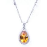 A citrine and diamond pendant and chain Centering an pear-shaped citrine surrounded by pavé-set