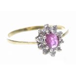 A ruby and diamond cluster ring The oval-shaped ruby to a round brilliant-cut diamond surround,